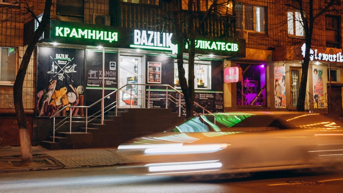 cars parked in front of store during night time